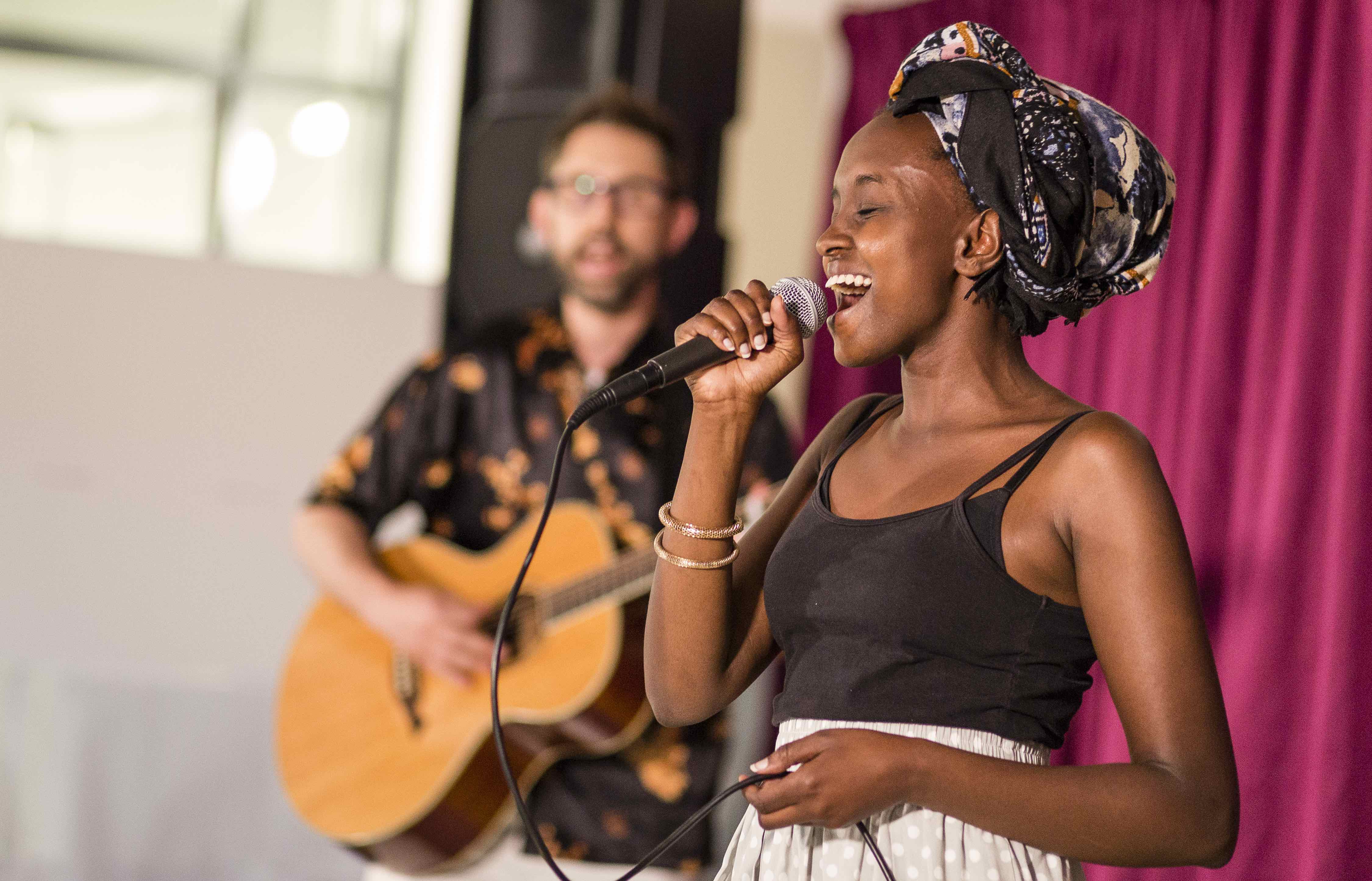 man playing guitar and woman singing