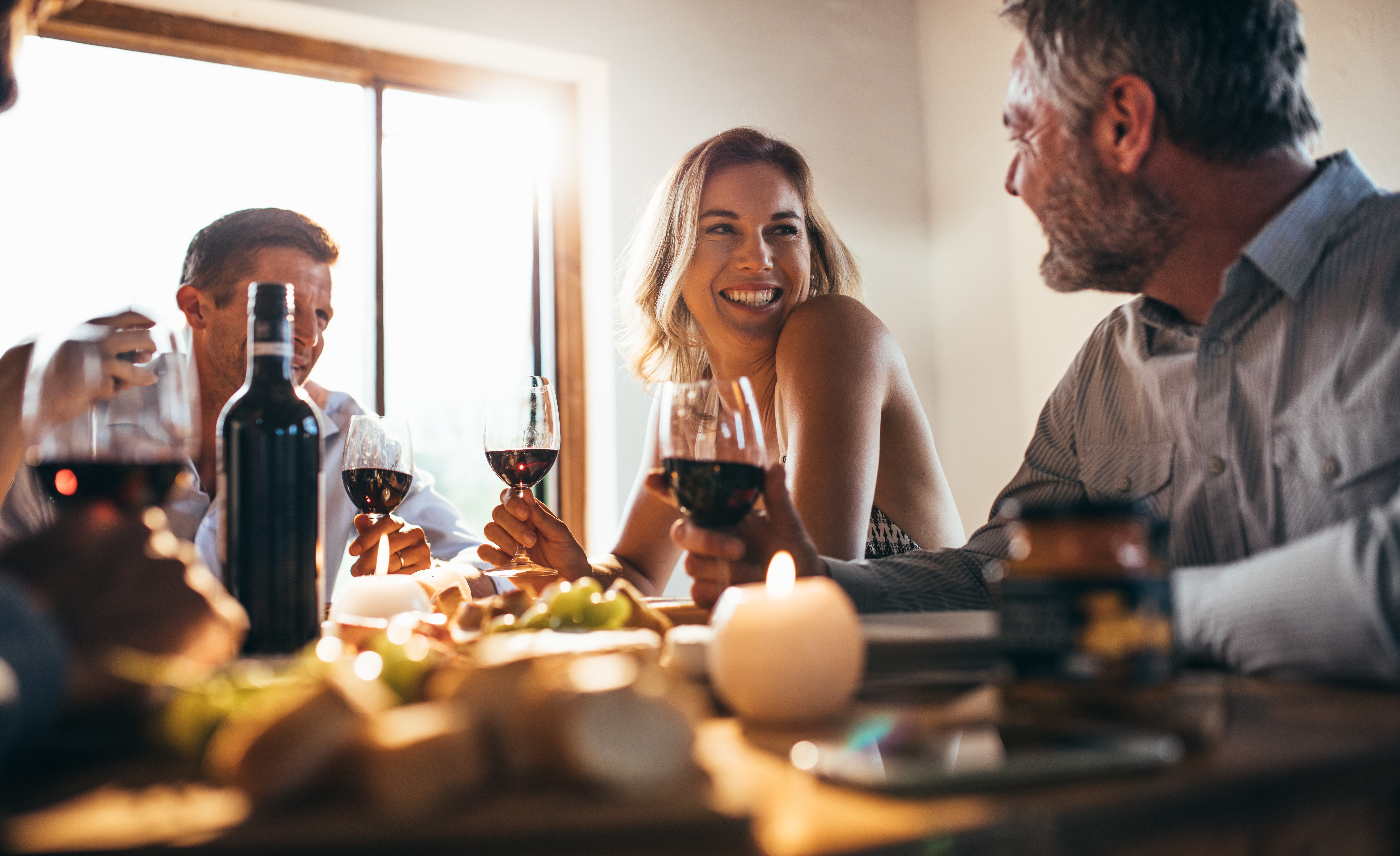 Woman holding wine talking to friends